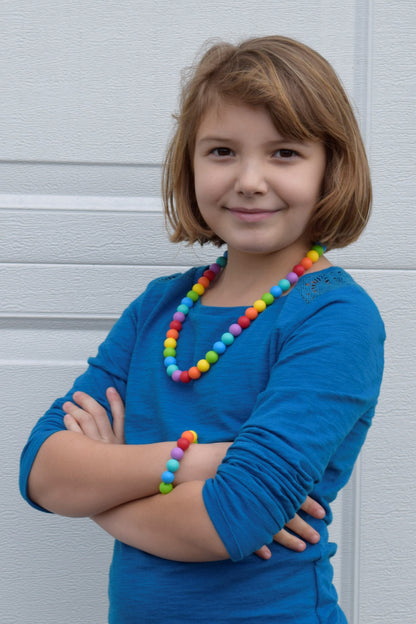 Munchables Rainbow Stimming chew Necklace worn by young girl.