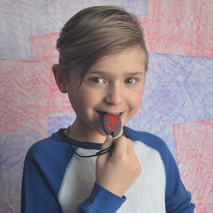 Boy chews on tip of Munchables Scorpion Chewelry in red