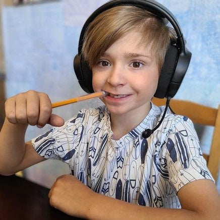 Boy chews on clear chewy tube pencil topper chewelry.