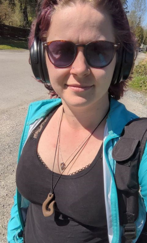 Woman wears brown fish hook chewable jewelry.