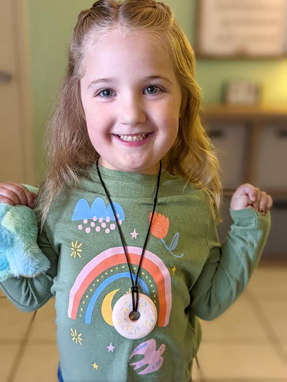 Young girl wearing pink donut anxiety necklace in Fort Worth, Texas.