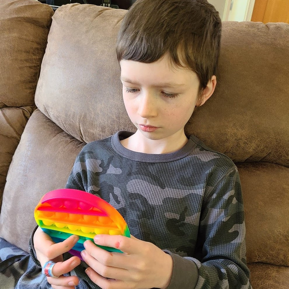 Boy plays with round pop it